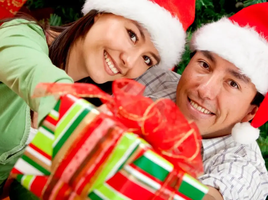 happy couple with christmas hats and gifts